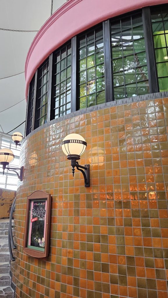 Glossy curved tile wall with warm colour, reflection, and rounded facade geometry.