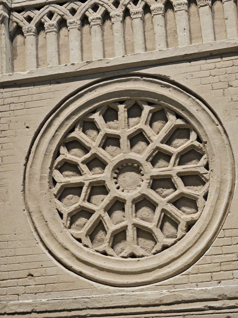 Circular sand relief with geometric pattern, shadow, and textured temporary ornament.