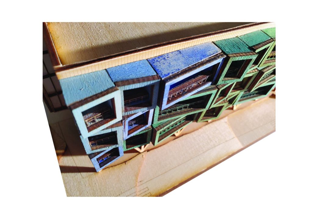 Physical model detail of facade and coloured dwelling modules.